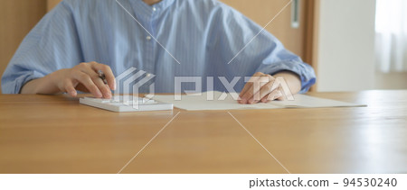 Woman using calculator at home. Household budget, payments, payments, budgets, loans, calculations, etc. 94530240