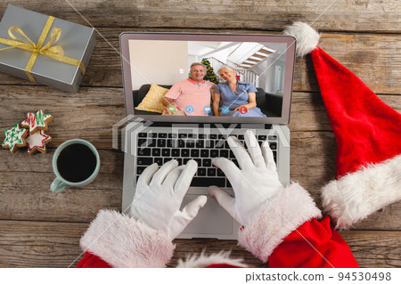 Santa claus on christmas laptop video call with caucasian couple Santa claus on christmas laptop video call with caucasian couple 94530498