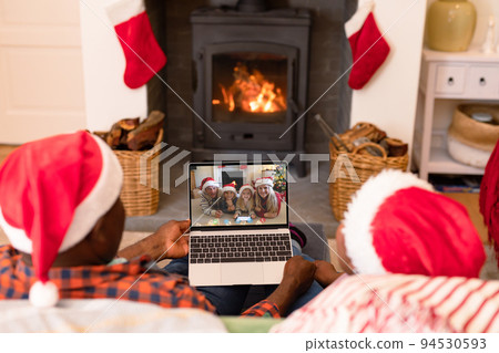 African american couple in santa hats on christmas video call with family 94530593