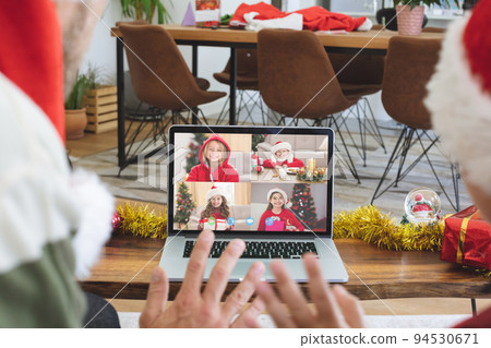 Caucasian couple in santa hat on christmas video call on laptop with children 94530671
