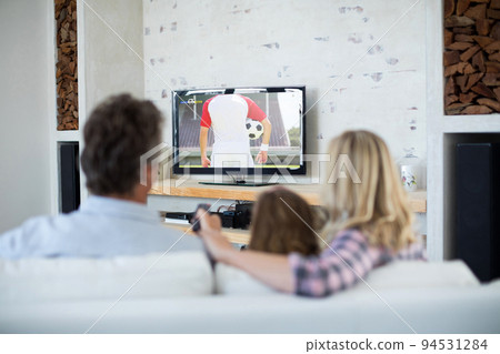 Caucasian family watching tv with football match on screen Caucasian family watching tv with football match on screen 94531284