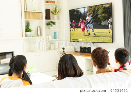 Diverse group of children siting on the couch and watching football match Diverse group of children siting on the couch and watching football match 94531451