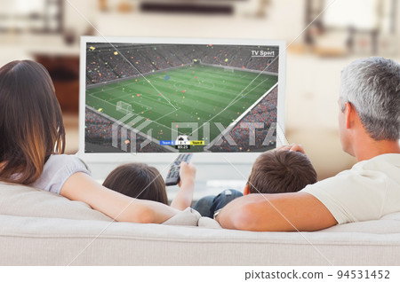 Caucasian family sitting on the couch and watching football match Caucasian family sitting on the couch and watching football match 94531452