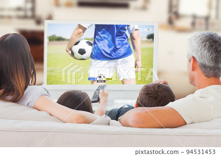 Caucasian family sitting on the couch and watching football match Caucasian family sitting on the couch and watching football match 94531453