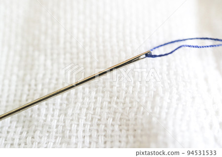 Needle and white gauze, blue thread in needle hole Needle and white gauze, blue thread in needle hole 94531533