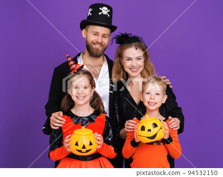 Cheerful family in carnival costumes celebrate Halloween on colored purple background Cheerful family in carnival costumes celebrate Halloween on colored purple background 94532150