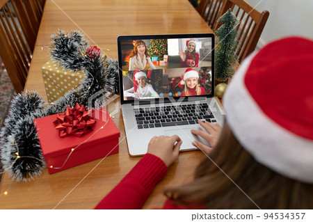 Caucasian woman in santa hat on christmas laptop video call with friends Caucasian woman in santa hat on christmas laptop video call with friends 94534357