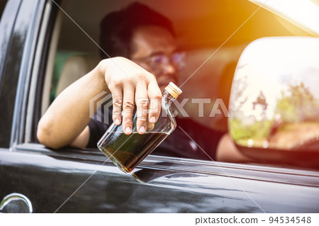 man drunk during drive a car. driver with alcohol whisky bottle dangerous and illegal concept. man drunk during drive a car. driver with alcohol whisky bottle dangerous and illegal concept. 94534548