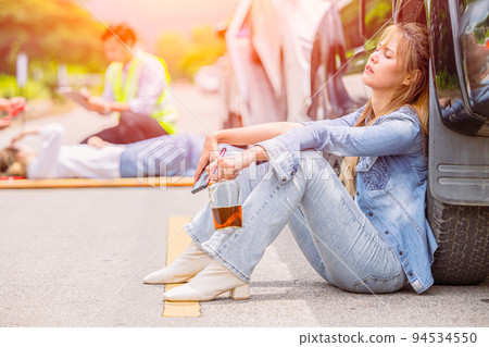 women teen drunk drink alcohol during drive a car accident at roadside sitting sleep unconscious women teen drunk drink alcohol during drive a car accident at roadside sitting sleep unconscious 94534550