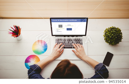 Caucasian woman using laptop with covid vaccination certificate and qr code on screen Caucasian woman using laptop with covid vaccination certificate and qr code on screen 94535014