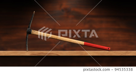 Pickaxe with Wooden Handle on a Wooden Workbench Pickaxe with Wooden Handle on a Wooden Workbench 94535338