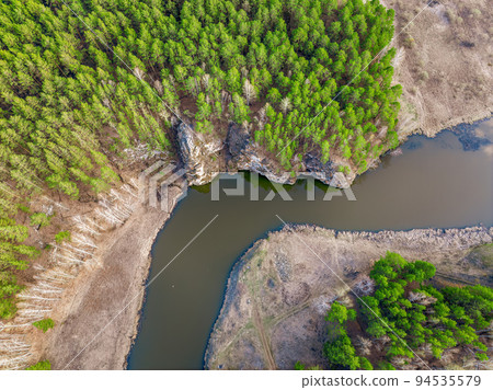 Aerial view of river shore with rocks and forest. Spring or autumn season. Iset River, Ural mountains, Russia. Aerial view of river shore with rocks and forest. Spring or autumn season. Iset River, Ural mountains, Russia. 94535579
