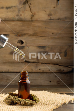 Vertical image of cbd oil in bottle on wooden background 94536142