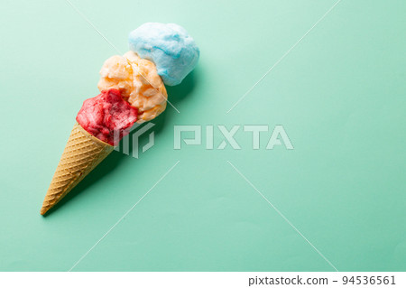 Horizontal image of three coloured flavours of ice cream in cone, on blue background with copy space Horizontal image of three coloured flavours of ice cream in cone, on blue background with copy space 94536561