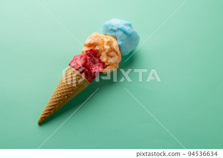 Horizontal image of three coloured flavours of ice cream in cone, on blue background with copy space Horizontal image of three coloured flavours of ice cream in cone, on blue background with copy space 94536634