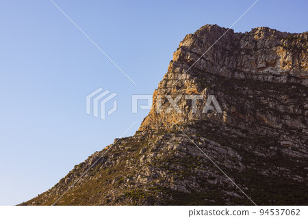Landscape of rocky mountains with scarce plants against cloudless blue sky Landscape of rocky mountains with scarce plants against cloudless blue sky 94537062