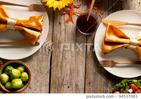 Thanksgiving table with plates, vegetables and autumn decoration with copy space on wood 94537063