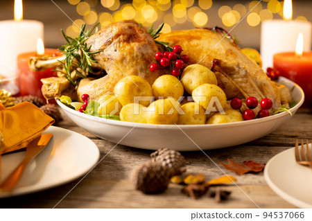 Thanksgiving table with roast turkey, potatoes, candles and autumn decoration Thanksgiving table with roast turkey, potatoes, candles and autumn decoration 94537066