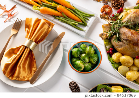 Overhead view of thanksgiving table with roast turkey, vegetables and autumn decoration on wood Overhead view of thanksgiving table with roast turkey, vegetables and autumn decoration on wood 94537069