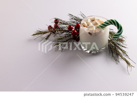 Image of glass of milk with marshmallows, candy cane, christmas decoration and copy space on white Image of glass of milk with marshmallows, candy cane, christmas decoration and copy space on white 94539247