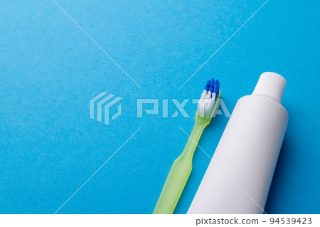 Image of toothbrush and toothpaste on blue surface 94539423