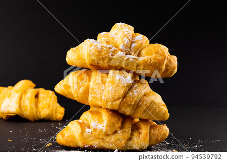 Image of croissants with powder sugar on black background 94539792