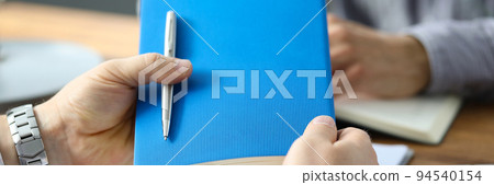 Businessman holding diary with pen at marketing meeting Businessman holding diary with pen at marketing meeting 94540154