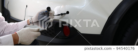 Mechanic installs parking sensors on car closeup Mechanic installs parking sensors on car closeup 94540176