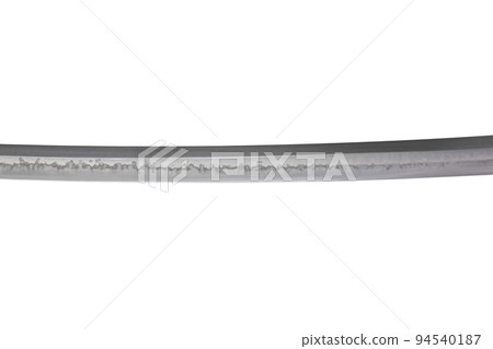 Japanese sword blade (made in China) on white background. Soft focus. The wavy pattern on the blade edge is a line of hardness that a blacksmith makes so that the blade doesn't break. Japanese sword blade (made in China) on white background. Soft focus. The wavy pattern on the blade edge is a line of hardness that a blacksmith makes so that the blade doesn't break. 94540187