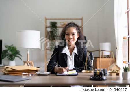 Portrait smiling female lawyer sitting at workplace in office 94540927