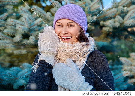 Happy middle aged woman looking at camera outdoor in winter Happy middle aged woman looking at camera outdoor in winter 94541045