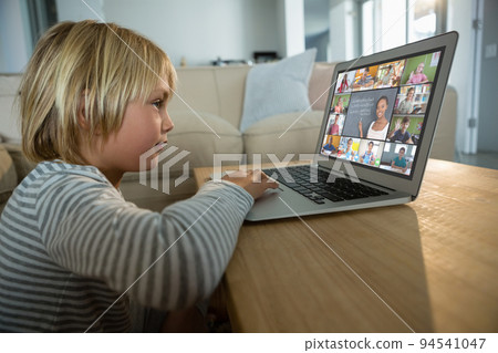 Caucasian boy using laptop for video call, with smiling diverse elementary school pupils on screen Caucasian boy using laptop for video call, with smiling diverse elementary school pupils on screen 94541047