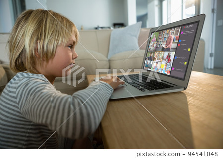 Caucasian boy using laptop for video call, with smiling diverse elementary school pupils on screen Caucasian boy using laptop for video call, with smiling diverse elementary school pupils on screen 94541048