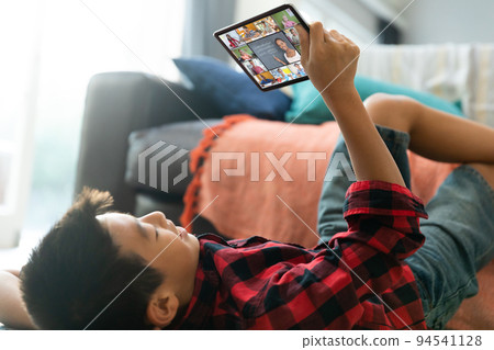 Smiling asian boy using laptop for video call, with diverse elementary school pupils on screen Smiling asian boy using laptop for video call, with diverse elementary school pupils on screen 94541128