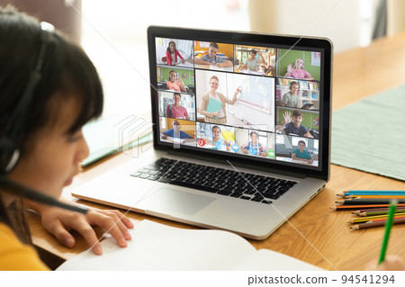 Asian girl using laptop for video call, with diverse elementary school pupils on screen Asian girl using laptop for video call, with diverse elementary school pupils on screen 94541294