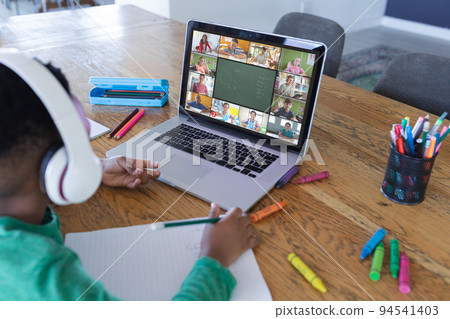 African american boy using laptop for video call, with diverse elementary school pupils on screen African american boy using laptop for video call, with diverse elementary school pupils on screen 94541403