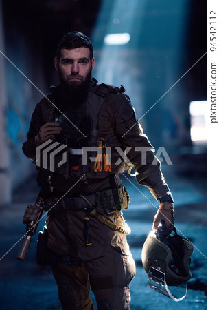 Army soldier in Combat Uniforms with an assault rifle and combat helmet night mission dark background. Blue and purple gel light effect.  94542112