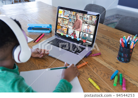 African american boy using laptop for video call, with diverse elementary school pupils on screen African american boy using laptop for video call, with diverse elementary school pupils on screen 94544253