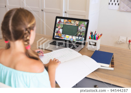 Caucasian girl using laptop for video call, with smiling diverse elementary school pupils on screen Caucasian girl using laptop for video call, with smiling diverse elementary school pupils on screen 94544287
