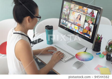 Asian girl holding computer for video call, with smiling diverse elementary school pupils on screen Asian girl holding computer for video call, with smiling diverse elementary school pupils on screen 94544382