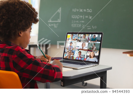 African american boy using laptop for video call, with diverse elementary school pupils on screen African american boy using laptop for video call, with diverse elementary school pupils on screen 94544393