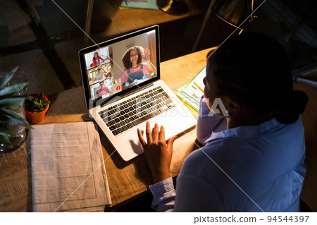 African american woman using laptop for video call, with diverse high school pupils on screen African american woman using laptop for video call, with diverse high school pupils on screen 94544397