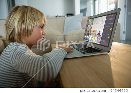 Caucasian boy using laptop for video call, with smiling diverse elementary school pupils on screen Caucasian boy using laptop for video call, with smiling diverse elementary school pupils on screen 94544453