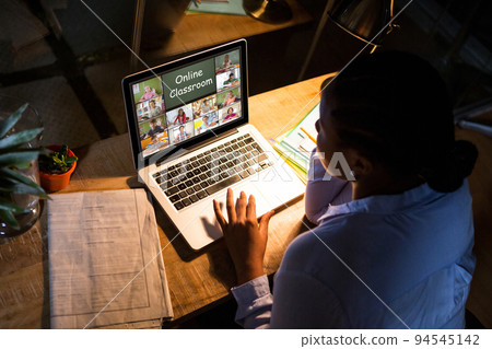 African american woman using laptop for video call, with diverse elementary school pupils on screen African american woman using laptop for video call, with diverse elementary school pupils on screen 94545142
