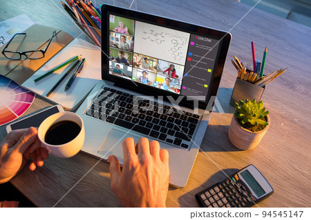 Hands of man using laptop for video call, with smiling diverse elementary school pupils on screen Hands of man using laptop for video call, with smiling diverse elementary school pupils on screen 94545147