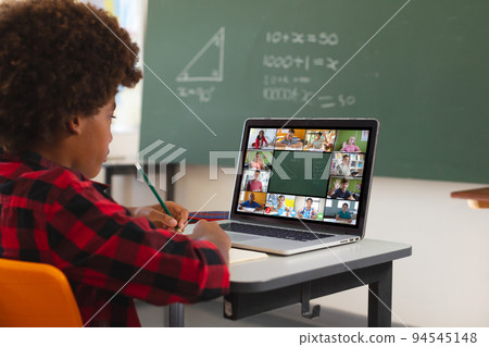 African american boy using laptop for video call, with diverse elementary school pupils on screen African american boy using laptop for video call, with diverse elementary school pupils on screen 94545148