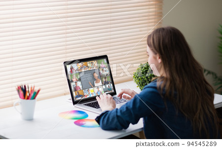 Caucasian girl using laptop for video call, with smiling diverse elementary school pupils on screen Caucasian girl using laptop for video call, with smiling diverse elementary school pupils on screen 94545289