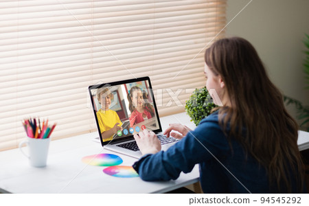 Caucasian girl using laptop for video call, with smiling elementary school pupils on screen Caucasian girl using laptop for video call, with smiling elementary school pupils on screen 94545292