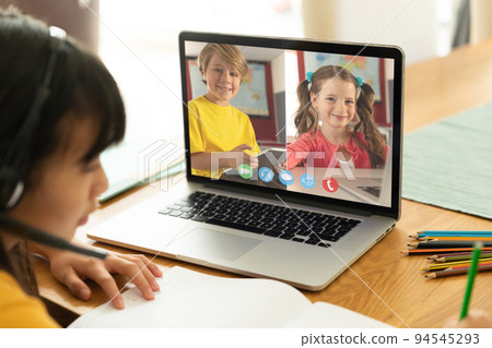 Asian girl using laptop for video call, with smiling caucasian elementary school pupils on screen Asian girl using laptop for video call, with smiling caucasian elementary school pupils on screen 94545293