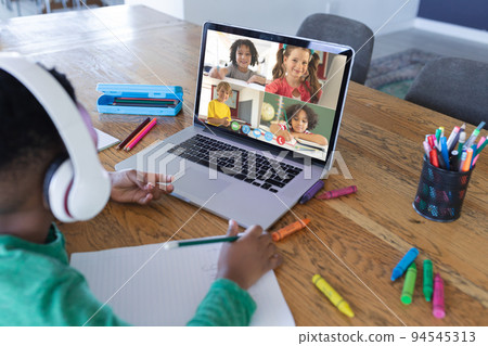 African american boy using laptop for video call, with diverse elementary school pupils on screen African american boy using laptop for video call, with diverse elementary school pupils on screen 94545313